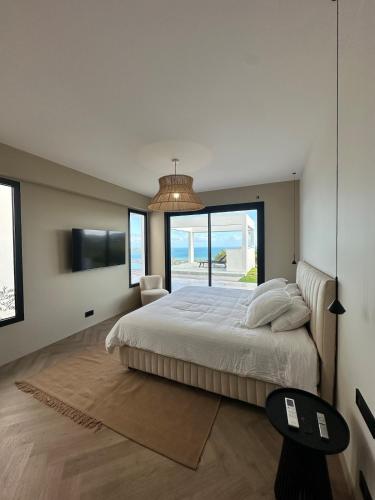 a bedroom with a large bed and a large window at Havre de paix luxueux avec vue mer imprenable in Dumbéa