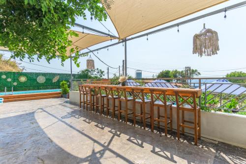 a row of benches under an umbrella on a patio at Chalet 1 With Jacuzzi In Monsef in Al Ḩulwah