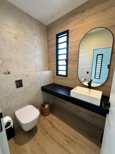 a bathroom with a white toilet and a mirror at Havre de paix luxueux avec vue mer imprenable in Dumbéa