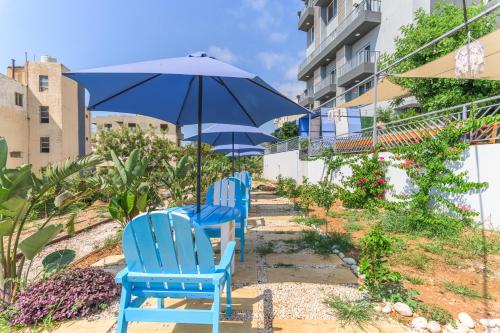 two blue chairs and an umbrella on a patio at Chalet 1 With Jacuzzi In Monsef in Al Ḩulwah