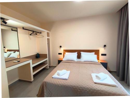 a bedroom with a bed with two white towels at Villa Maroula in Afantou