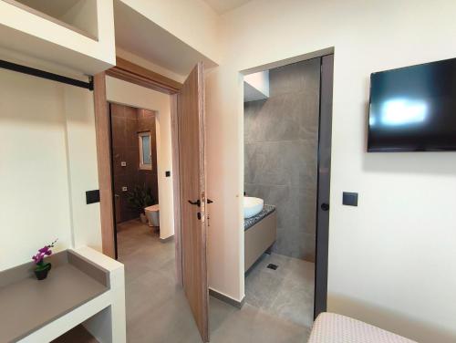 a bathroom with a toilet and a sink and a mirror at Villa Maroula in Afantou