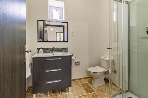 une salle de bain avec un lavabo et des toilettes dans l'établissement Le Chai Villa, à Thénac