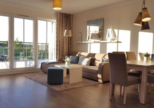 a living room with a couch and a table at Aparthotel Waterkant Suites - Fewos am Meer mit SPA in Börgerende-Rethwisch