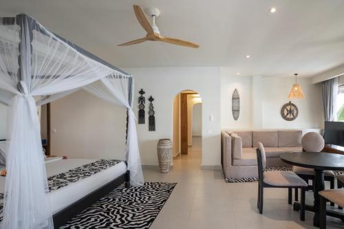 a bedroom with a bed and a living room at Kiwengwa Beach Resort in Kiwengwa