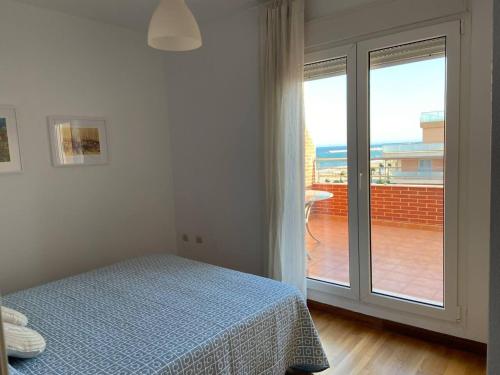 een slaapkamer met een bed en een groot raam bij Brisamarina Playa Apartamento in Roquetas de Mar