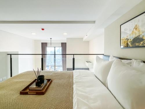 a bedroom with a large white bed with a tray on it at Elegant 1BR Condo - Ultra Fast WiFi - BTS On-Nut in Bangkok
