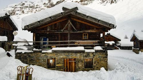 una cabaña de madera con nieve encima en Lechnerhütte Fane Alm, en Valles