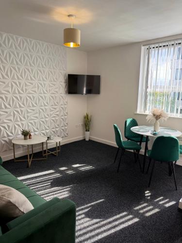 a living room with a green couch and a table at Luxury and Cosy Apartment near Old Trafford M16 ,Free Private Parking,Fast Wi-Fi,Self Check-In Anytime Perfect For Late Arrivals, 5 Minutes to Old Trafford Stadium in Manchester