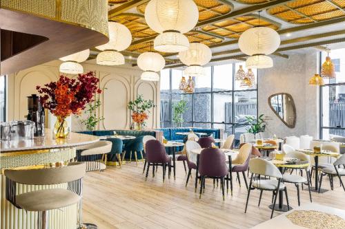 a restaurant with tables and chairs and chandeliers at Vertus Hotel and Suites in Benin City