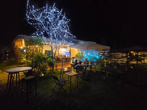 Chaba2 في Ban Nong Bua Noi: مجموعة من الناس يجلسون على الطاولات في المطعم في الليل
