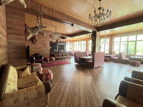 a lodge lobby with couches and a antlers on the wall at Shahdag Boutique Hotel in Laza
