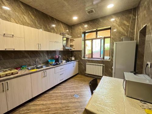 a kitchen with white cabinets and a refrigerator at Shahdag Boutique Hotel in Laza