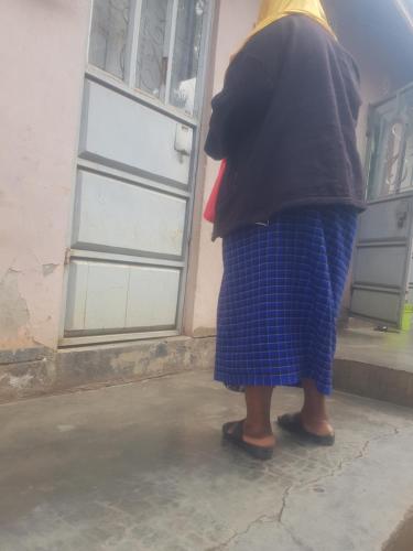 Una mujer está parada frente a una puerta en othman homes, en Arusha