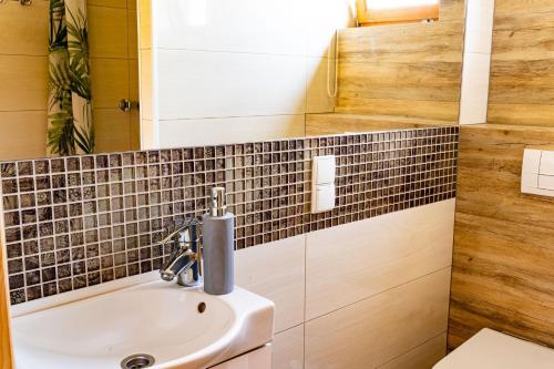 a bathroom with a sink and a mirror at Domki Nad Satwem Mazury D2 in Mrągowo