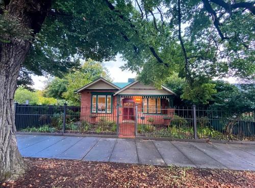 a house with a red telephone booth in front of a fence at Executive Cottage, Luxe 1930s Stay in the Heart in Albury