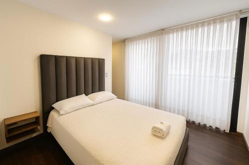a bedroom with a large bed and a large window at Apartamento moderno en el centro in Pasto