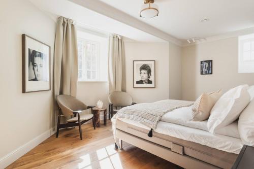 a bedroom with a bed and two chairs in it at CygnusPool °BBQ °Sauna °Parking °King °Netflix°Gym in Oslo