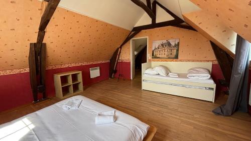 a room with two beds in a attic at Maison familiale à la campagne in Vallères