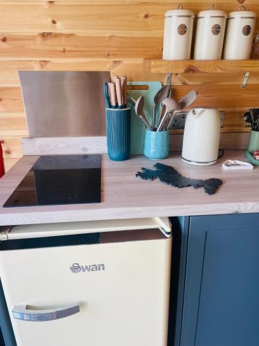 a kitchen counter top with a stove and utensils at Crofters Coorie in Broadford