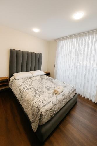 a bedroom with a large bed with a large window at Apartamento moderno en el centro in Pasto