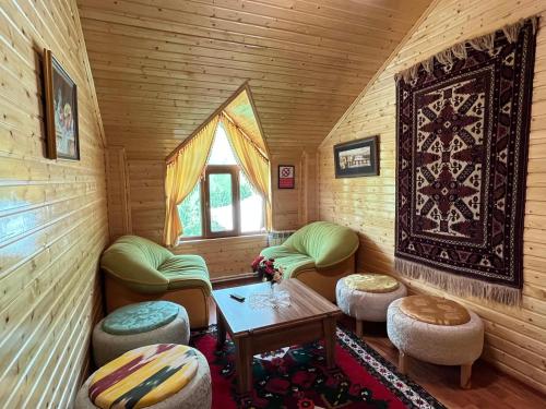 a room with chairs and a table in a log cabin at Shahdag Boutique Hotel in Laza