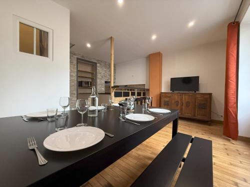 eine schwarze Theke mit zwei Waschbecken und Weingläsern in der Unterkunft Maison au cœur d Orgelet in Orgelet