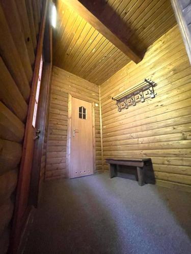 a wooden room with a bench and a door at Готель Пацьорка in Kremintsi