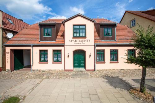 a building with a green door in a courtyard at Richtenberger Ente Apartments Ferienwohnungen in Richtenberg