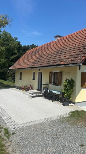 a house with a table and chairs in front of it at Ferienhaus Neuhold in Kitzeck im Sausal