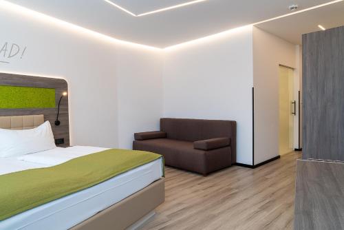 a bedroom with a bed and a chair at CHRIZZ Rooms in Graz