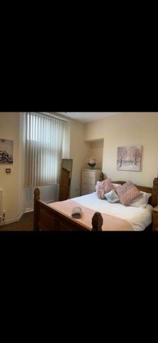a bedroom with a large bed with white sheets at 34 - Room 4 - Uplands in Swansea