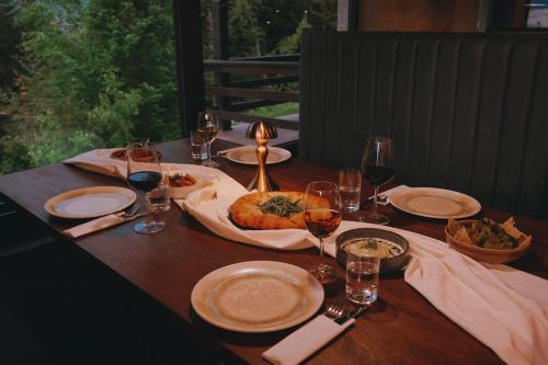 a wooden table with food and wine glasses on it at Lilat Hotel in Mestia