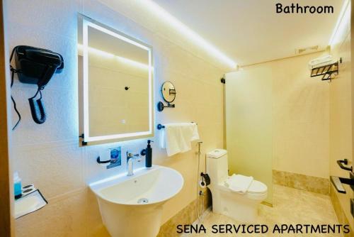 a bathroom with a sink and a toilet and a mirror at Sena Serviced Apartments in Al Madinah