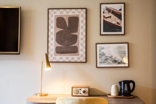 a room with a desk with a clock and pictures on the wall at Home Hotel Havnekontoret in Bergen