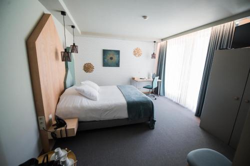 a hotel room with a bed and a desk at ABCD - Hôtel-restaurant in Beauraing
