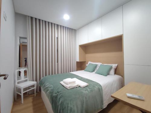a bedroom with a bed with two towels on it at Barcelos Habadia House in Lijó