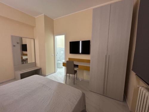 a bedroom with a bed and a desk with a television at L Oasi di Lauria in Lauria