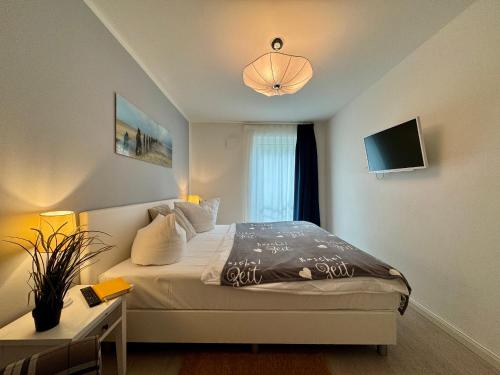 a bedroom with a bed and a tv on the wall at Aquamarin Ostseetraumsuite 05 in Neuhaus