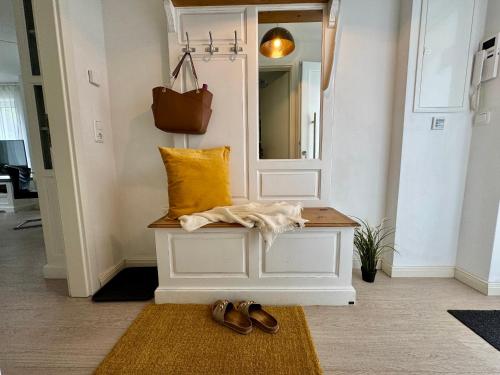 a hallway with a bench with a mirror and shoes at Aquamarin Ostseetraumsuite 05 in Neuhaus