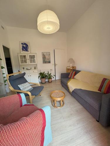 a living room with a bed and a couch at Le Jean Moulin Vert in Sète