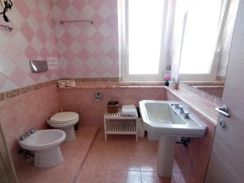 a bathroom with a sink and a toilet at Casa Vacanze Brezza Marina with beautiful garden in Quartu SantʼElena