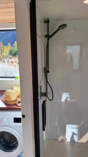 a shower in a kitchen with a washing machine at Grace & Rose in Gibbston