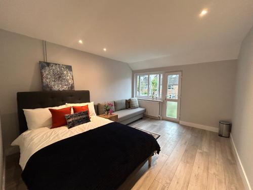 a bedroom with a bed and a couch and a window at Modern Rooms - Walk to Kings Cross - Central in London