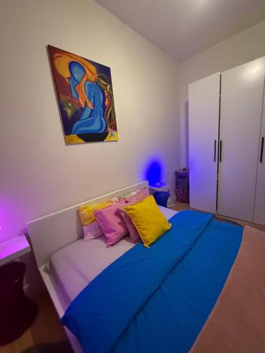 Schlafzimmer mit einem Bett mit blauen und gelben Kissen in der Unterkunft Antwerpen duplex apartment in Antwerpen