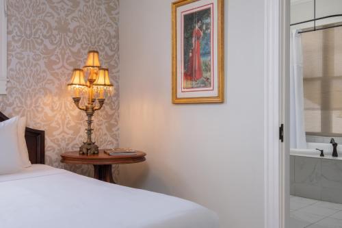 a bedroom with a bed and a lamp on a table at National Hotel Jackson, Tapestry Collection by Hilton in Jackson