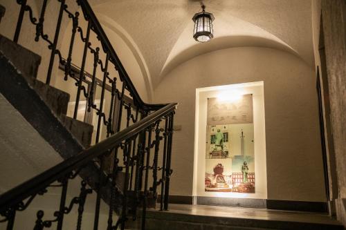 a hallway with a staircase with a light at the top at Home Hotel Havnekontoret in Bergen