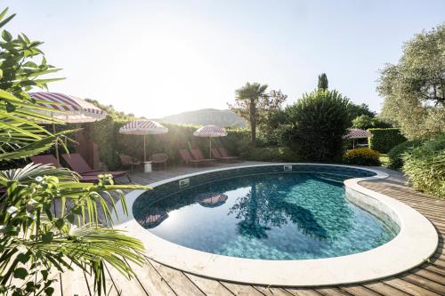 a swimming pool in a yard with chairs and umbrellas at Boutique Guesthouse GIUS La Damaglück in Marciaga