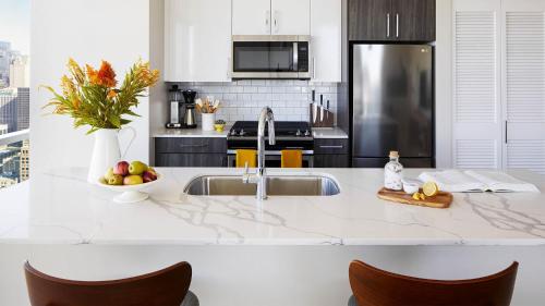 a kitchen with a sink and a counter with chairs at Sentral Michigan Avenue in Chicago