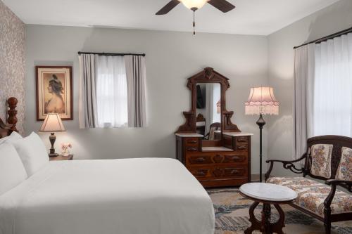 a bedroom with a bed and a chair and a mirror at National Hotel Jackson, Tapestry Collection by Hilton in Jackson